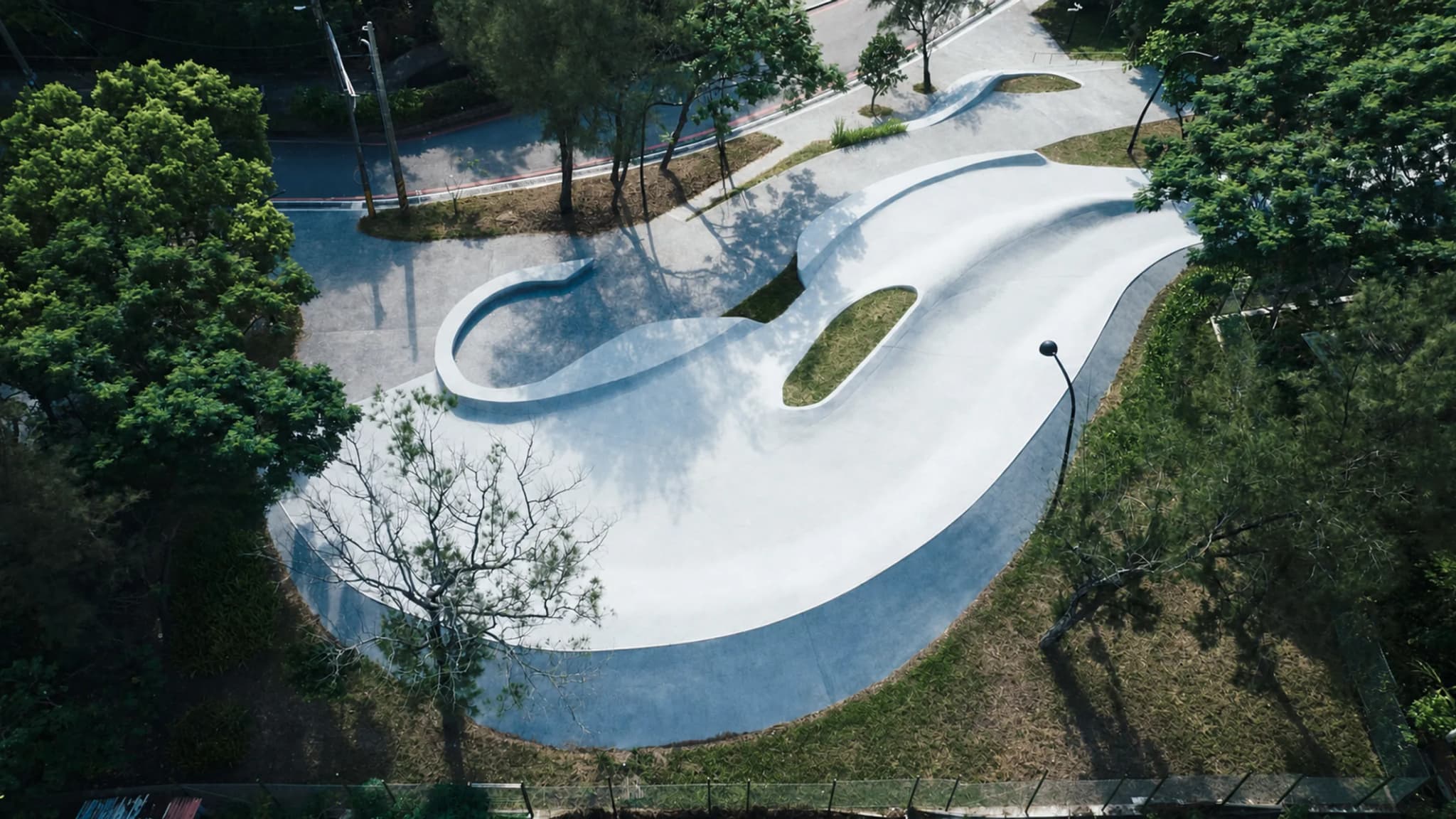 Các mặt bê tông uốn lượn, đường tập và cây xanh tại Wai'ao Surfskate Park